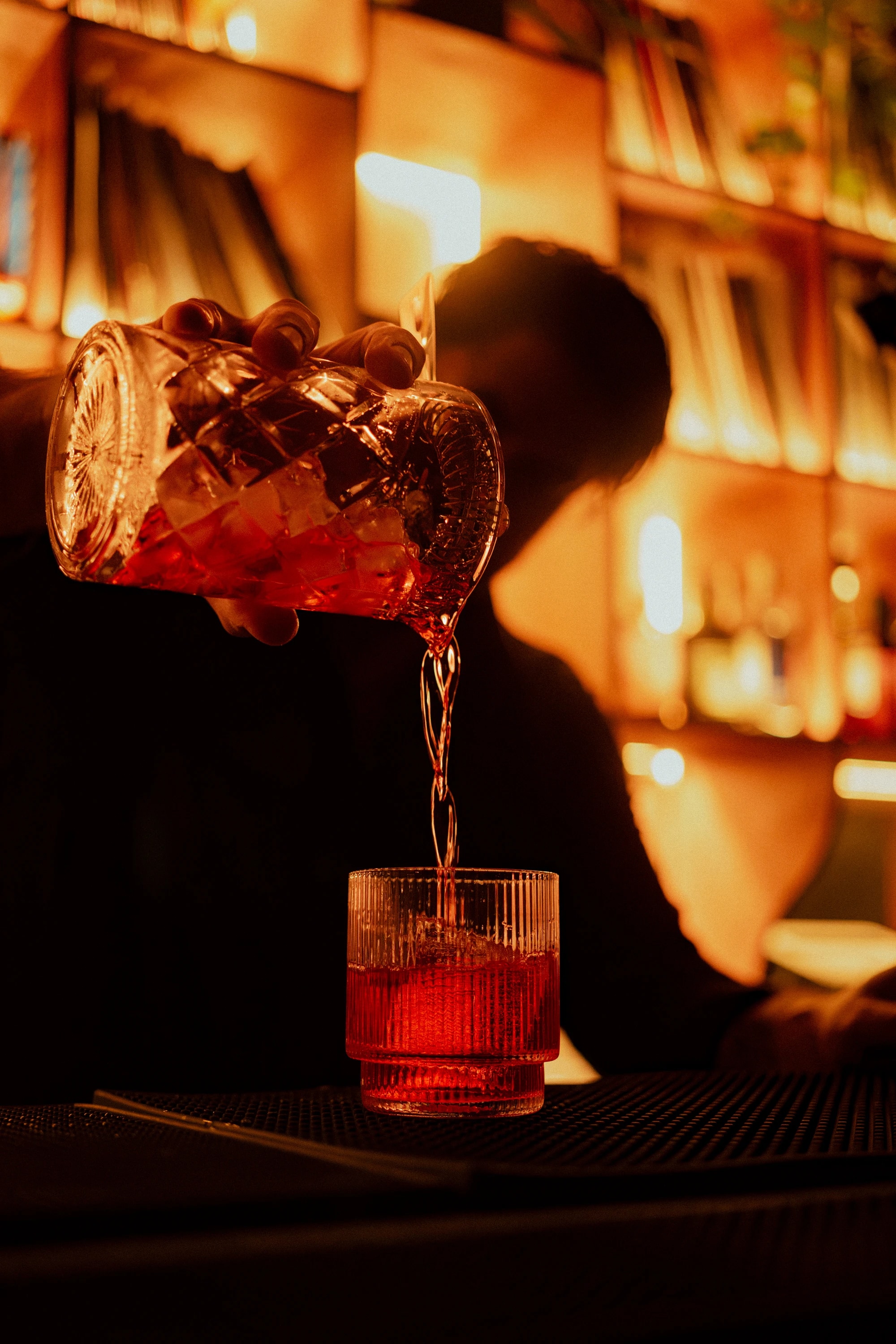 A red cocktail being poured at the bar